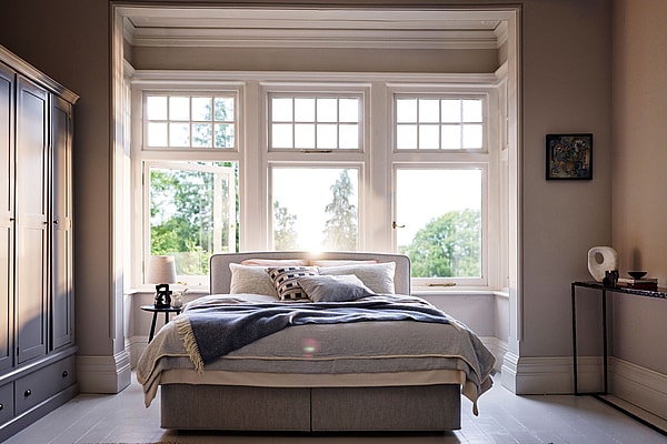 A Vispring bed set in front of a large bay window