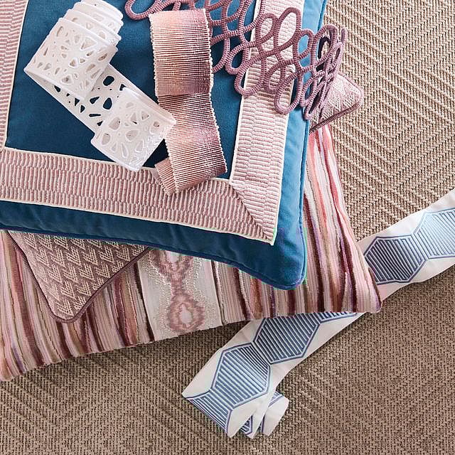 Stacked cushions with loose trimmings by Kendall Wilkinson unfurled on top and alongside