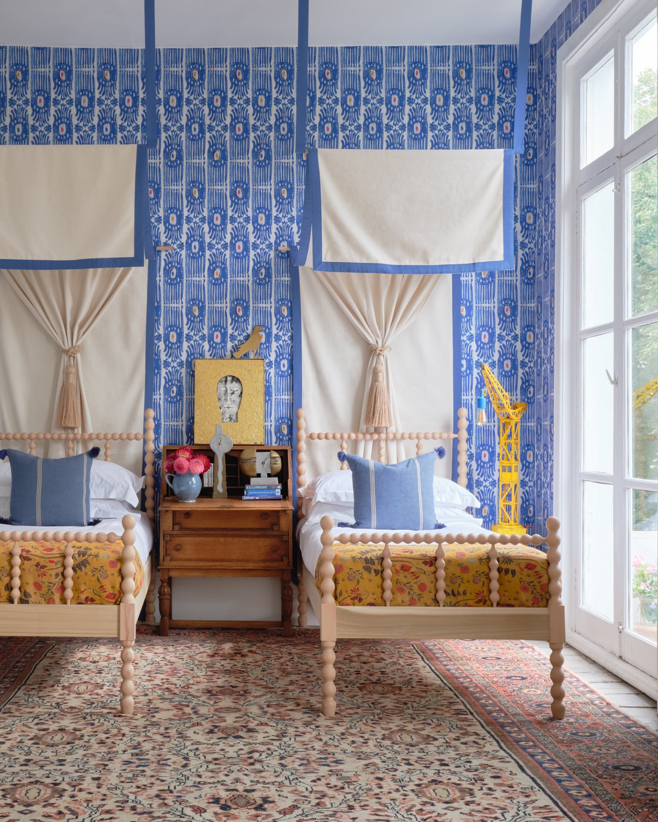 A bedroom with MindtheGap's Ikat Carnical wallpaper on the walls